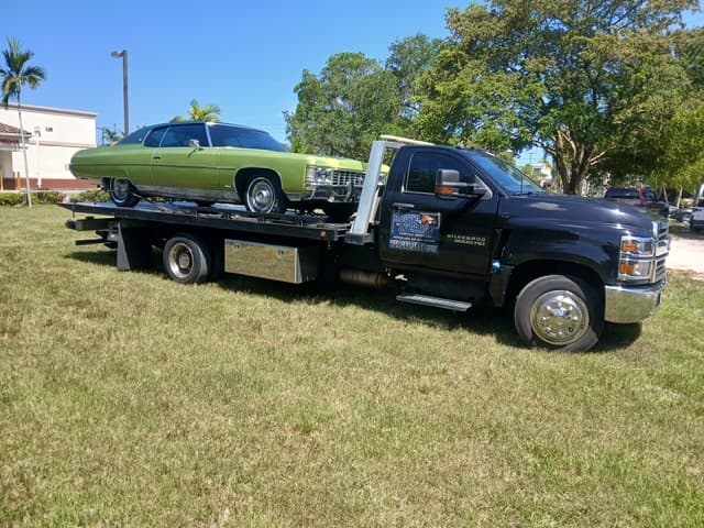 Green early 1970s Chevrolet Caprice classic on the flatbed under full sun